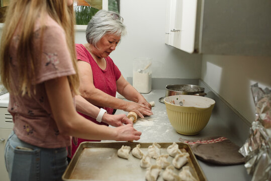 Woman and teen making potstickers