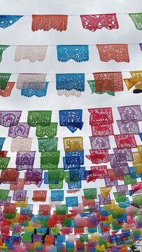 Brightly colored papel picado flags in the sunshine