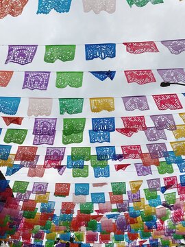 Brightly colored papel picado flags in the sunshine