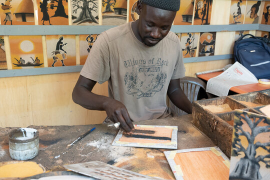 painter artist artisan creating a painting with sand
