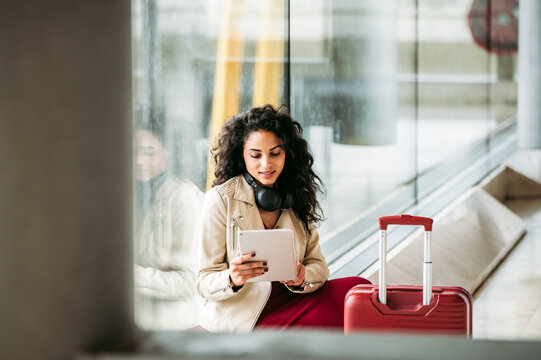 Happy woman using tablet at airport