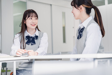 教室で休み時間に話す女子高生