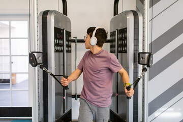 Teenager working out with pulley gym machine
