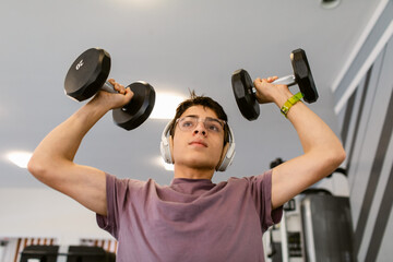 Teenager Boy lifting weights at gym
