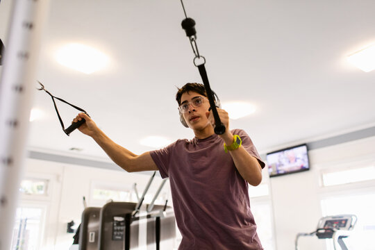 Teenager using gym machine