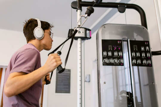 Teenage boy muscle-building At Gym