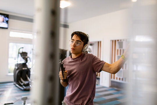 Handsome teenage boy working out in gym