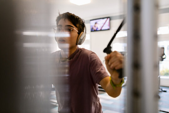 Teen boy muscle-building At Gym