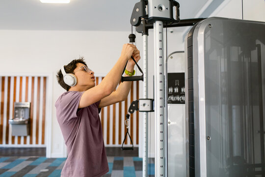 Teenager preparing gym pulley machine