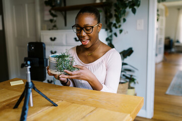 Smiling black girl vlogging about plants in her home