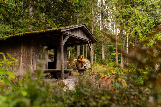 woman in wooden cabin in forest