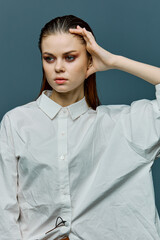 a beautiful, elegant woman with her hair laid back and evening makeup is standing in a light shirt...