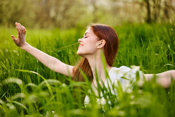 sunny summer day, a beautiful young woman lying on the grass