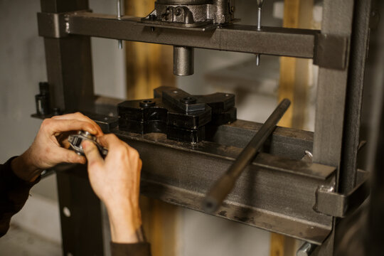 Mechanic worker installing bearings with a hydraulic press 
