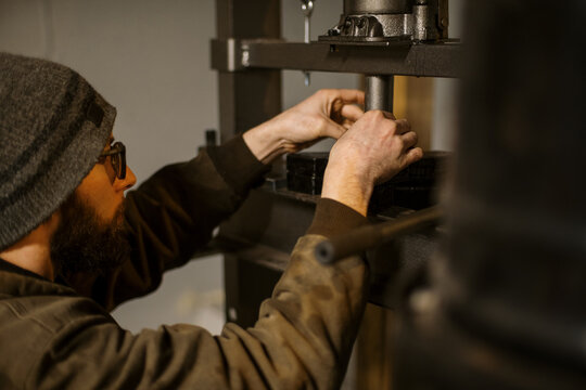 Mechanic worker installing bearings with a hydraulic press 