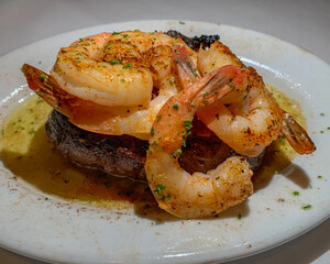 Juicy steak on sizzling butter topped with jumbo shrimp. Surf and turf.