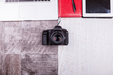 Over top photo of camera and laptop on wooden background