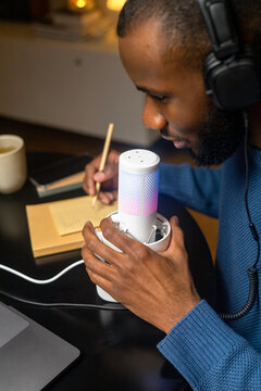 A man edits a script in a notebook before recording a podcast