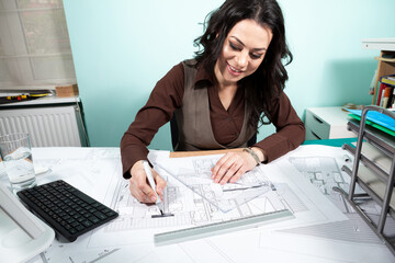 Woman on working desk with blueprints in front of her. Working on new projects. Architecture and design