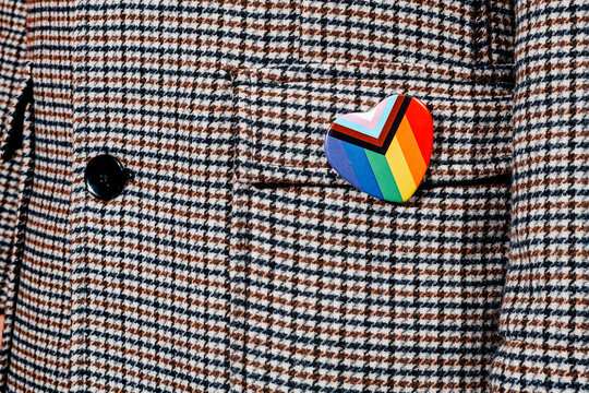 heart-shaped badge with the progress pride flag