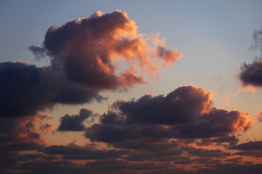 dramatic orange and dark blue clouds in the sky at sunset