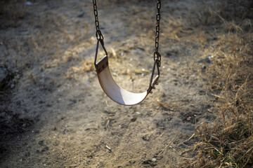 Lonely old swing in the sunset, blurred background, selective focus