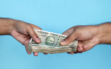 Hand Giving Indian 500 Rupee Bank Notes. concept for earnings or spend in Agriculture.