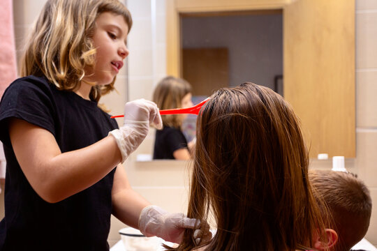 Girl dyeing her mother's hair