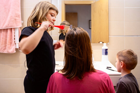 Girl dyeing her mother's hair