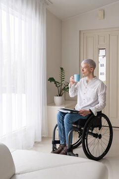 Woman Drinking Coffee And Using Tablet At Home
