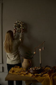 woman hangs an Easter wreath