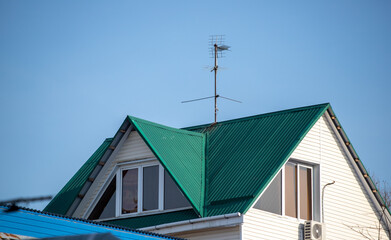 Roofs of houses with dormer windows against the sky. Urban architecture.