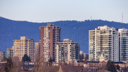 Fototapeta na wymiar Residential apartment buildings in North Vancouver, British Columbia, Canada. Mountain landscape in background
