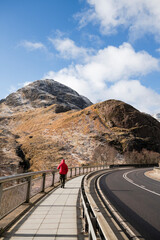Solo man walking the sidewalk in Scottish highlands