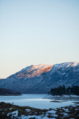 View of Scottish highland mountains at dusk across Loch Cluanie