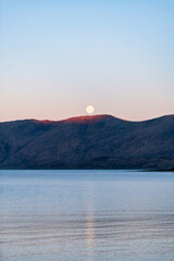 Full moon over a mountain ridge in the Scottish highlands