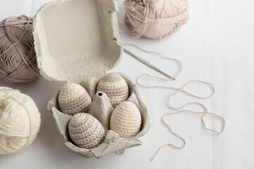 Fototapeta na wymiar Set of cute easter crocheted eggs, pastel color in the eggbox