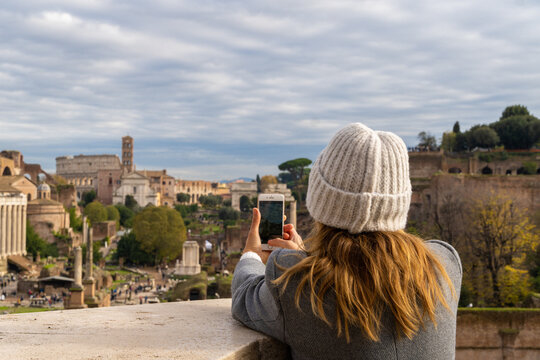 Tourist woman taking picture with her mobile phone in Rome city Italy