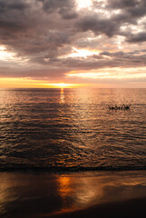 Three people swimming in the ocean at sunset in Costa Rica.