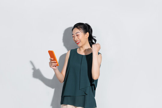Asian beautiful woman raise arm up and holding smartphone