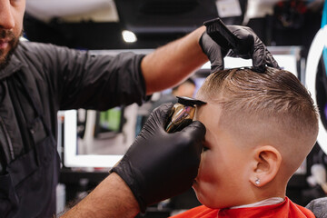 Adult male barber lining up child's edges in Portland, Oregon