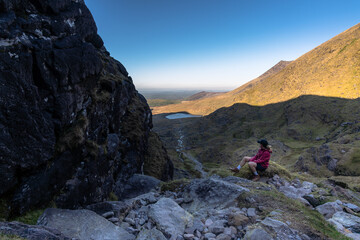 Woman sit on top of mountain admiring the landscape