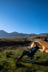 Fototapeta premium female traveler camper enjoying the sun and a coffee