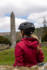 Traveler Woman cyclist by the St. Kevin Church in Glendalough