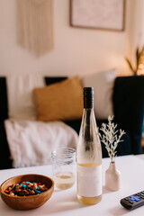 Cozy living room with snacks, chilled wine, + remote on coffee table
