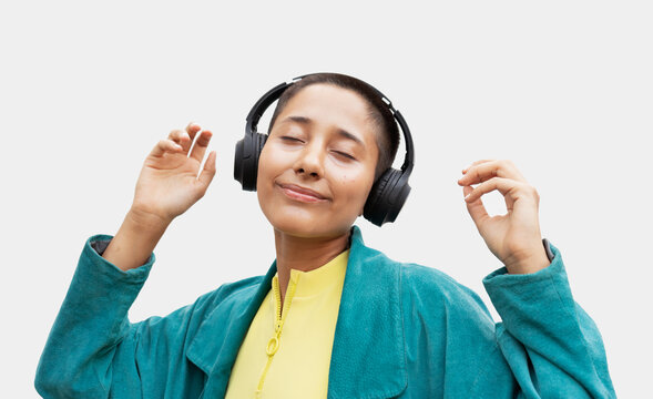 Young bald woman listening music with wireless headphones
