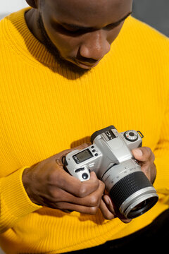 Photographer with a film camera in a yellow sweater