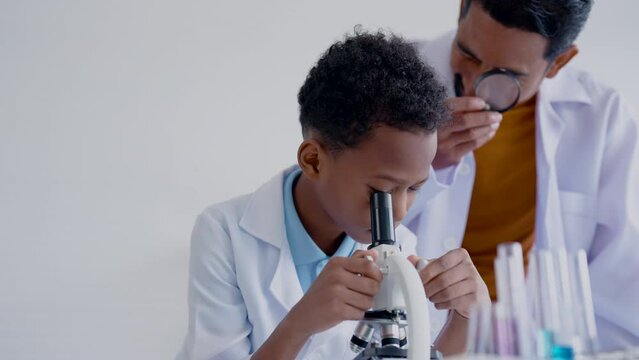 4K, Close-up male student, under microscope, in order able use in real-life chemistry experiments in science class, teaches about use microscope, then rotates magnifying glass align vision.