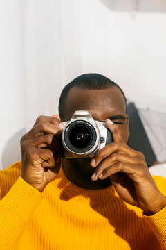 Photographer with a film camera in a yellow sweater