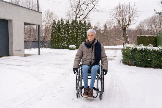 Woman In Wheelchair Outdoors At Winter
